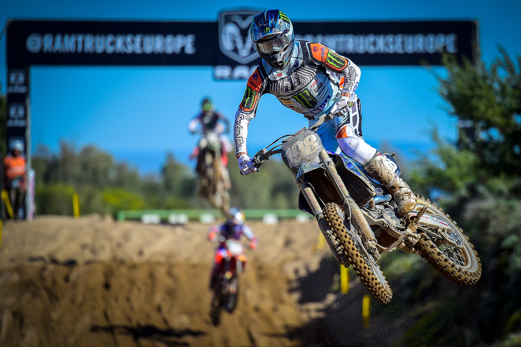 Motocross rider jumping with other riders in the background
