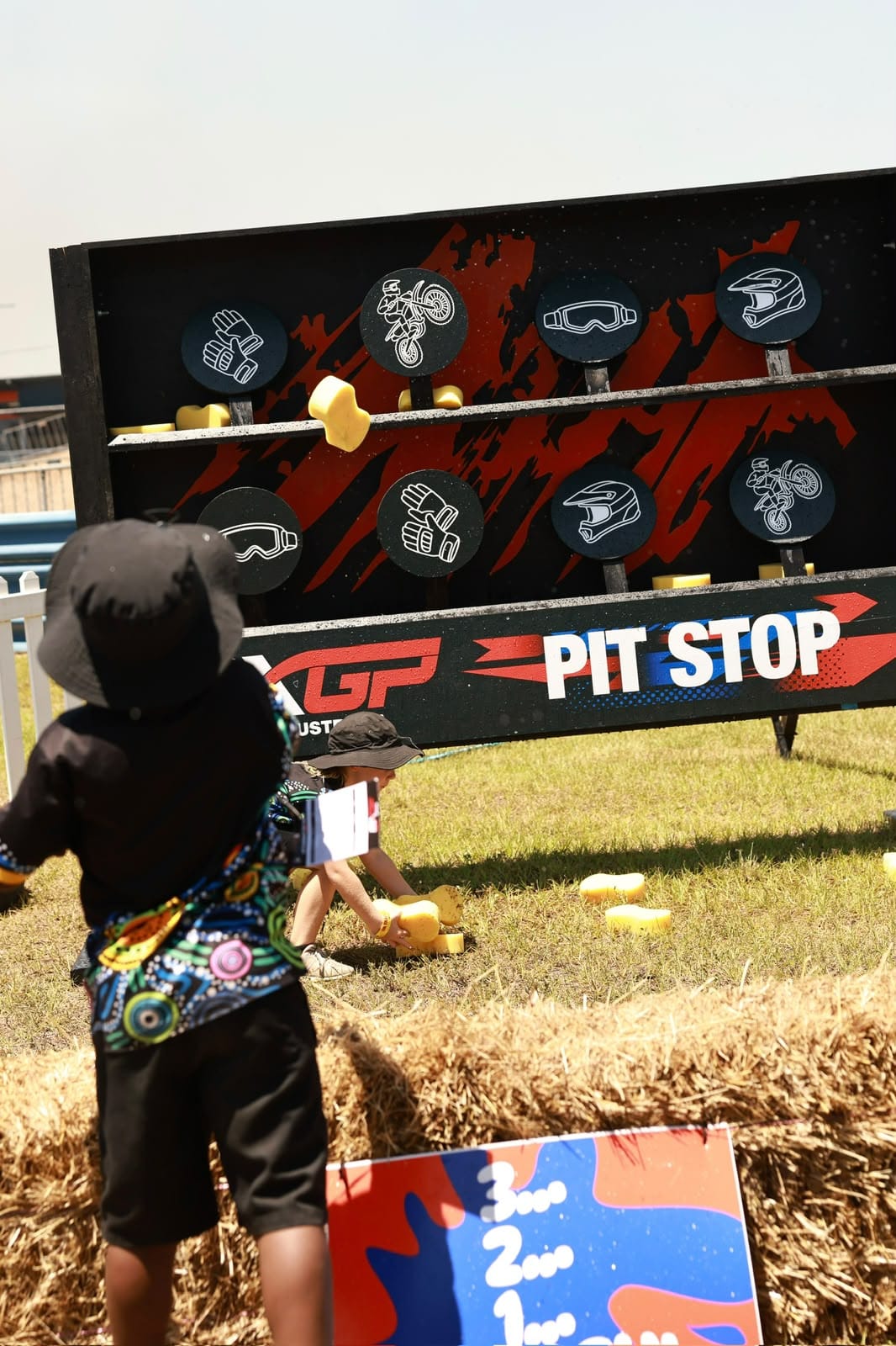 Children taking part in a motocross-themed pit stop activity in the family entertainment area at MXGP of Australia.