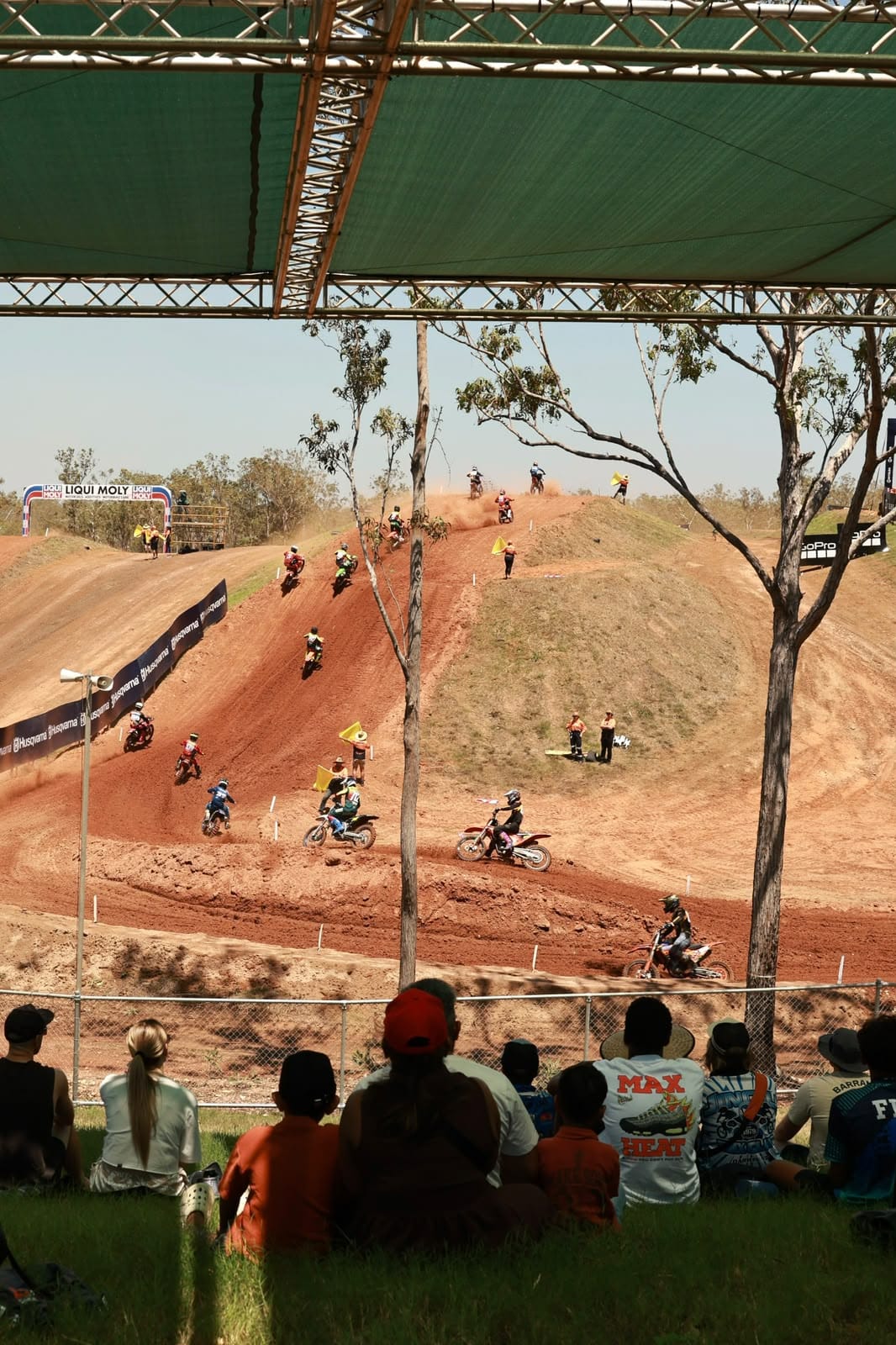 Spectators watching motocross riders race across the red dirt track at Hidden Valley during MXGP of Australia.