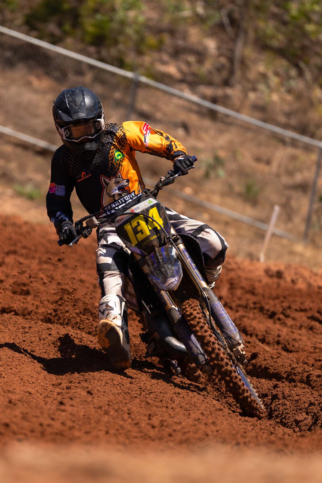 Territory motocross rider number 134 leans through a deep red dirt corner at MXGP of Australia.
