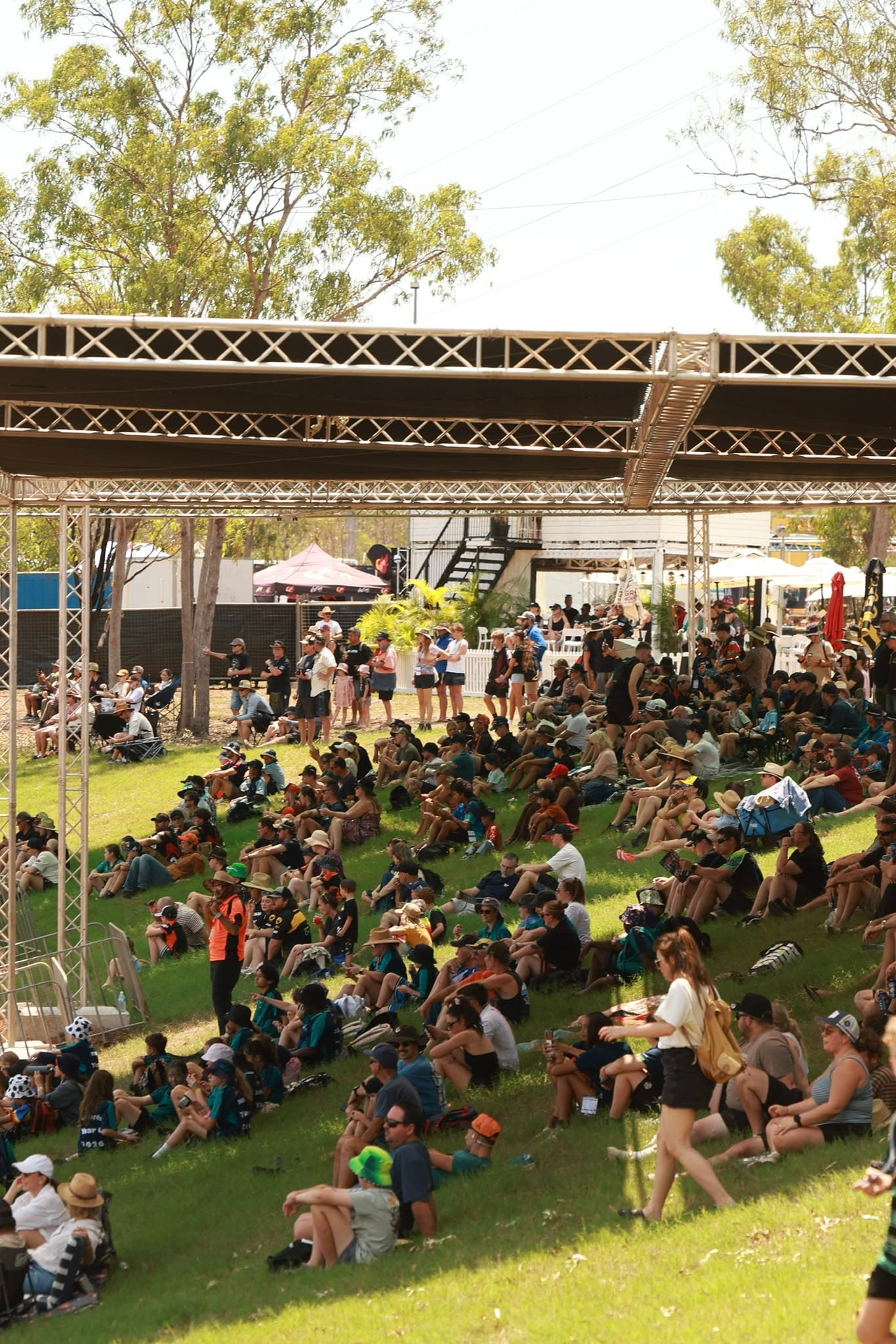 Large crowd of spectators seated on a shaded grassy viewing area at MXGP of Australia in Darwin.