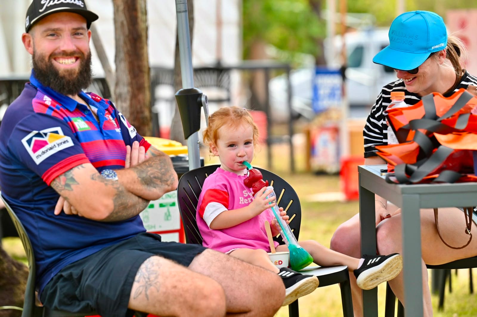 Family relaxes in the spectator area, with a young child enjoying a colourful drink during MXGP Australia in Darwin.